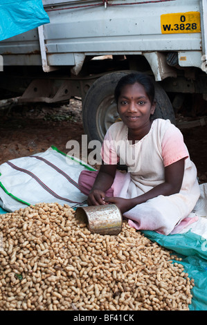 Young Indian girl selling peanuts at an Indian market. Puttaparthi, Andhra Pradesh, India Stock Photo