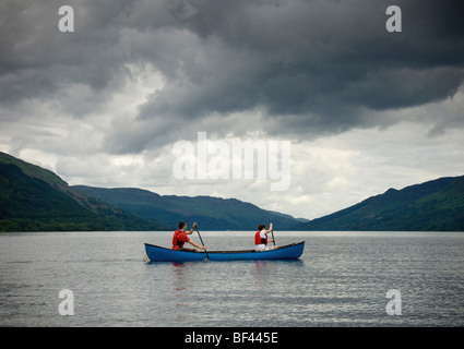 Young caucasian man and woman paddling a Canadian canoe on Loch Earn, Perthshire, Scotland. UK Stock Photo