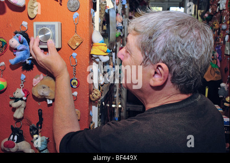 An elderly woman adjusting the thermostat on her central heating system Stock Photo