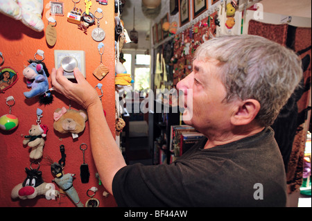 An elderly woman adjusting the thermostat on her central heating system Stock Photo