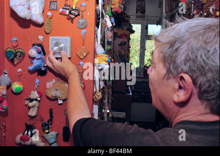 An elderly woman adjusting the thermostat on her central heating system Stock Photo