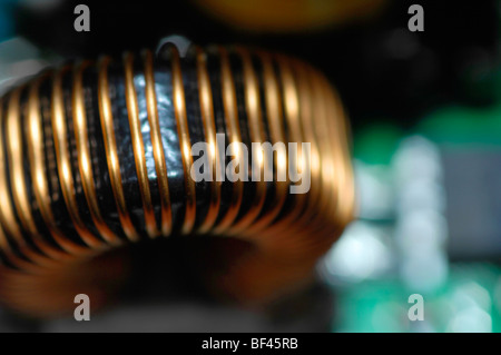 Macro close-up of electronics.  This image illustrates an inductor or transformer formed on a toroid in a printed circuit board. Stock Photo