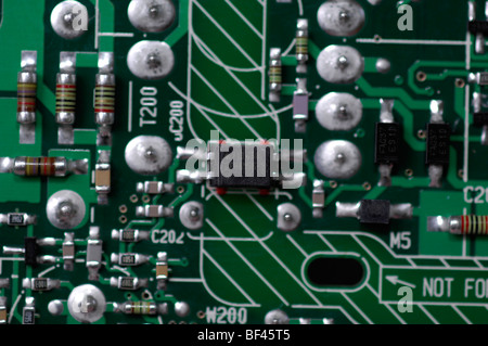 Macro close-up of electronics showing a four-terminal integrated circuit & several precision resistors and other devices. Stock Photo