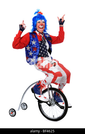 Clown riding a unicycle with training wheels Stock Photo
