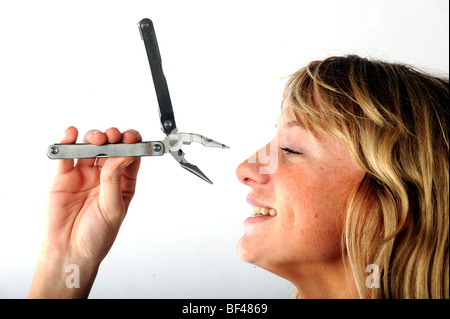 Blonde model with Rolson leatherman style retractable toolkit including knives pliers and screwdriver Stock Photo