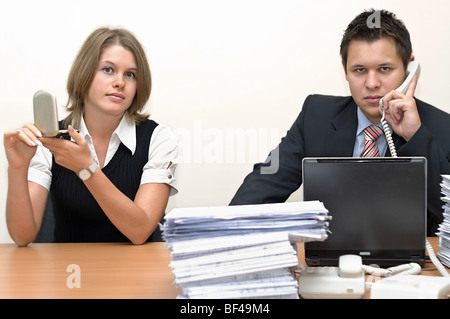 The working businessman and the lazy woman the secretary. On a white background. The office Stock Photo