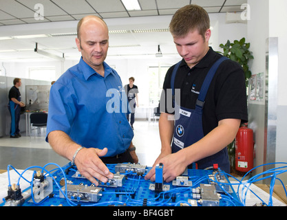 Master, Andreas Fischer, explaining an electric circuit to an apprentice in the BMW training center for automotive mechatronics Stock Photo