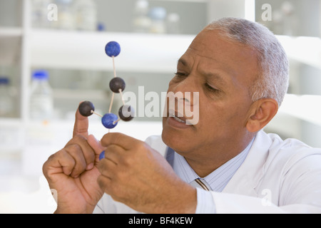 African scientist viewing molecule model in laboratory