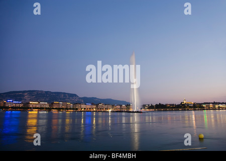 Illuminated Jet d'Eau (one of the largest fountains in the world) and St. Pierre Cathedral at night, Lake Geneva, Geneva Stock Photo