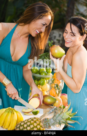 Hispanic friends preparing fresh fruit Stock Photo