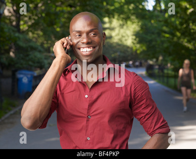 Smiling African man using cell phone Stock Photo
