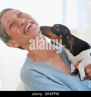 Dachshund licking Chinese woman's face Stock Photo