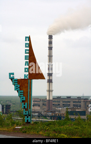 Industrial coal mining landscape with smoke stack and 1950's style sign, Vorkuta, Komi Republic, Arctic Russia Stock Photo