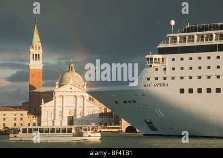 Italy, Venice, Vaporetto and MSC OPERA cruise ship pass San Giorgio Maggiore Church, Sunset with Rainbow Stock Photo