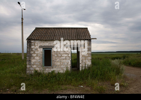 Empty abandoned hut building in field landscape, Urals, Russia Stock Photo