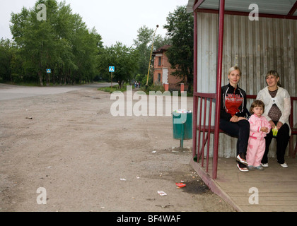 Women and child waiting in village bus shelter, portrait,  Urals, Russia Stock Photo