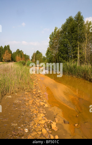 River water orange from chemical waste pollution discharged from factories, Karabash, Ural, Russia Stock Photo