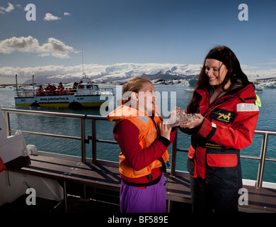 Girl touching glacial ice, Jokulsarlon Glacial Lagoon, Iceland Stock Photo