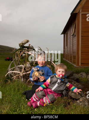 Young children on farm,  Reindeer antlers in background,  Eskifjordur, Iceland Stock Photo