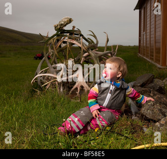 Young girl on farm,  Reindeer antlers in background,  Eskifjordur, Iceland Stock Photo