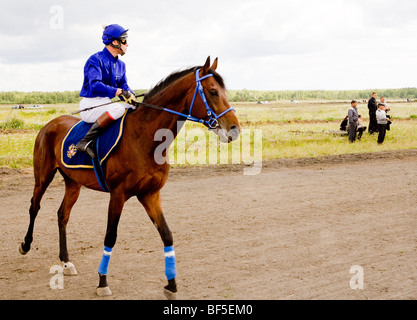 Jockey and spectators at horse race event, Urals, Russia Stock Photo