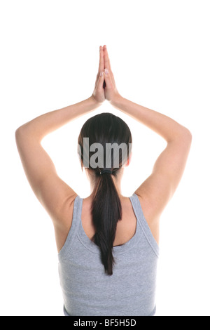 Rear view of a brunette woman doing yoga with her hands above her head, isolated on a white background. Stock Photo