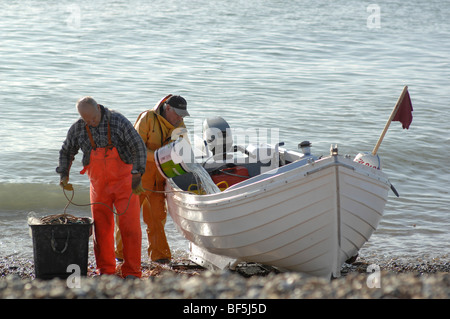Fishermen with their catch on the beach Stock Photo