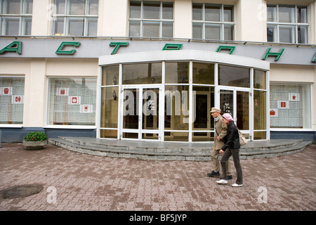 Senior adult man and young woman walking by building, Ural Mash, Yekaterinburg, Russia Stock Photo