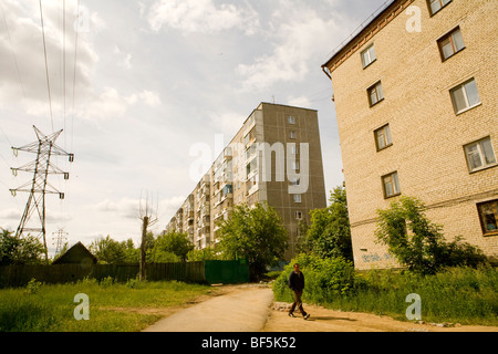 apMan walking past apartment blocks, Ekaterinburg, Urals, Russia Stock Photo