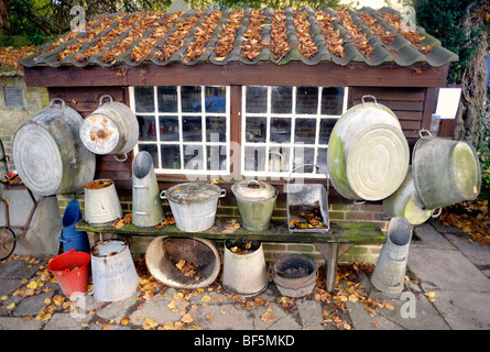 Tin pans buckets and tubs hanging on a shed wall Stock Photo