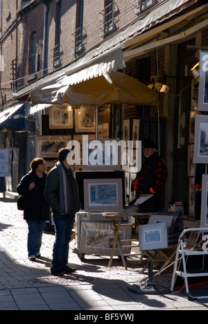 Artists sell their art to tourists in Saint-Amable Street, also known as Rue des Artistes, in Old Montreal. Stock Photo