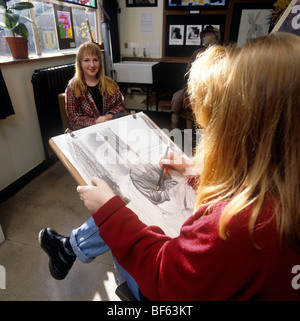 Education Art lesson in sixth-form college, girl making drawing of fellow student Stock Photo