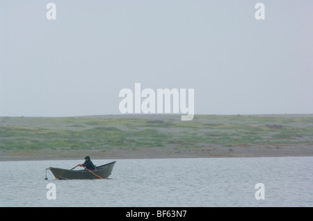 Fisherman in small dory boat in the rain and fog on Big Lagoon, Humboldt Lagoons State Park, California Stock Photo