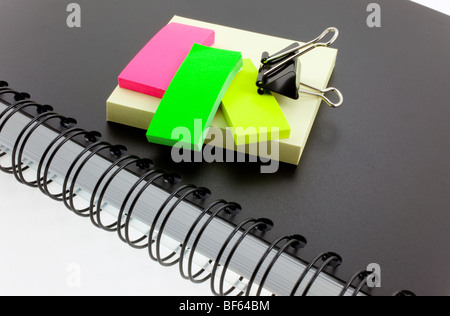 black personal organizer, multicolor post-its and steel clip Stock Photo
