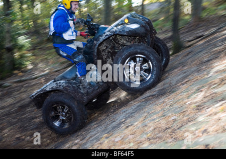 Man rides all-terrain vehicle (ATV) on steep terrain. Trial off-road biking Stock Photo