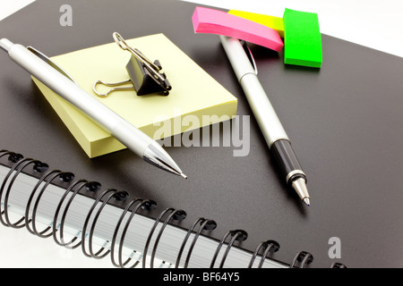 black personal organizer, multicolor post-its, silver pen, pencil and steel clip Stock Photo