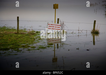 Fencing and signage in a flooded field, Pulborough, West Sussex, England. Stock Photo