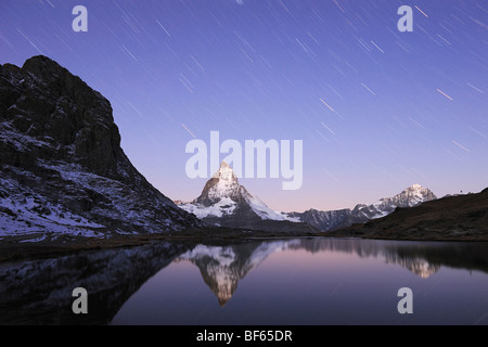 Matterhorn at night with star trails in winter with reflection in the Riffelsee, Zermatt, Valais, Switzerland, Europe Stock Photo