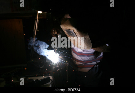 Man welding with fire sparks flying into the air Stock Photo