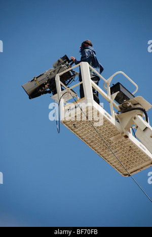 A television cameraman shoots a sporting event from an elevated camera platform Stock Photo