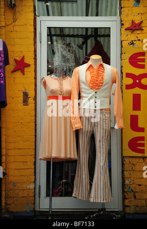 Examples of sixties and seventies era vintage clothing fashions for sale displayed on mannequins outside  a Toronto secondhand clothes shop. Stock Photo