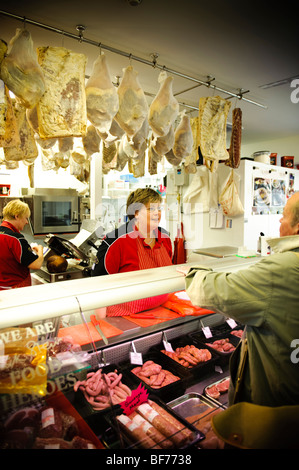 A woman working at a butchers shop stall in the new Carmarthen indoor market, Wales UK, 2009 Stock Photo