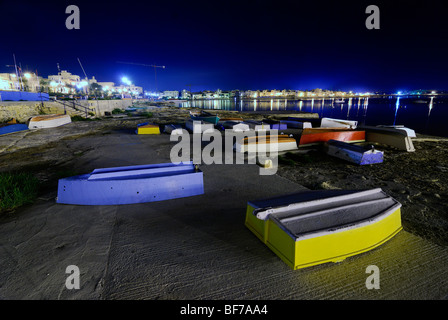 landscape picture of a beach at night with fishing boats and punts Stock Photo