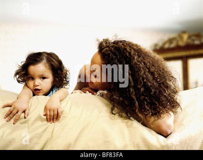 Mother and daughter laying on bed Stock Photo