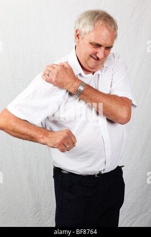 Mature 60s man suffering with osteoarthritis rheumatoid arthritis in his shoulder joint, painful inflamed stiff joint Stock Photo