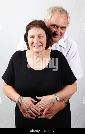 Married older early retired silver grey couple 60s hugging holding each other looking happy relaxed loving caring in love Stock Photo