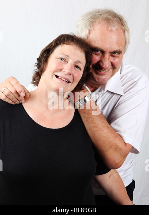 Older mature married couple husband and wife cuddling looking happy contented relaxed loving caring early retired Stock Photo