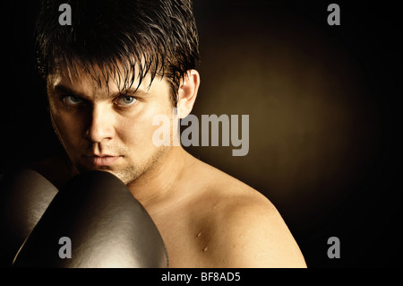 The boxer. The young man in boxing gloves Stock Photo