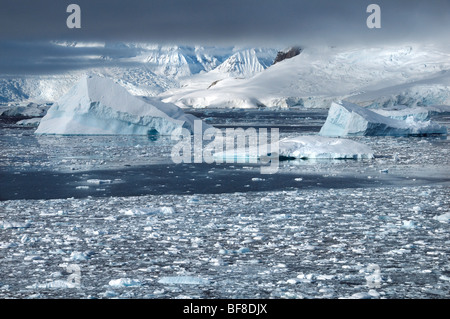 A view across the frozen landscape and icebergs of Charlotte Bay in Antarctica Stock Photo