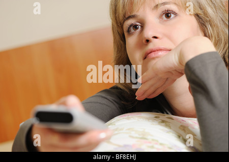 The woman with a television control panel. House conditions. Selective focus Stock Photo